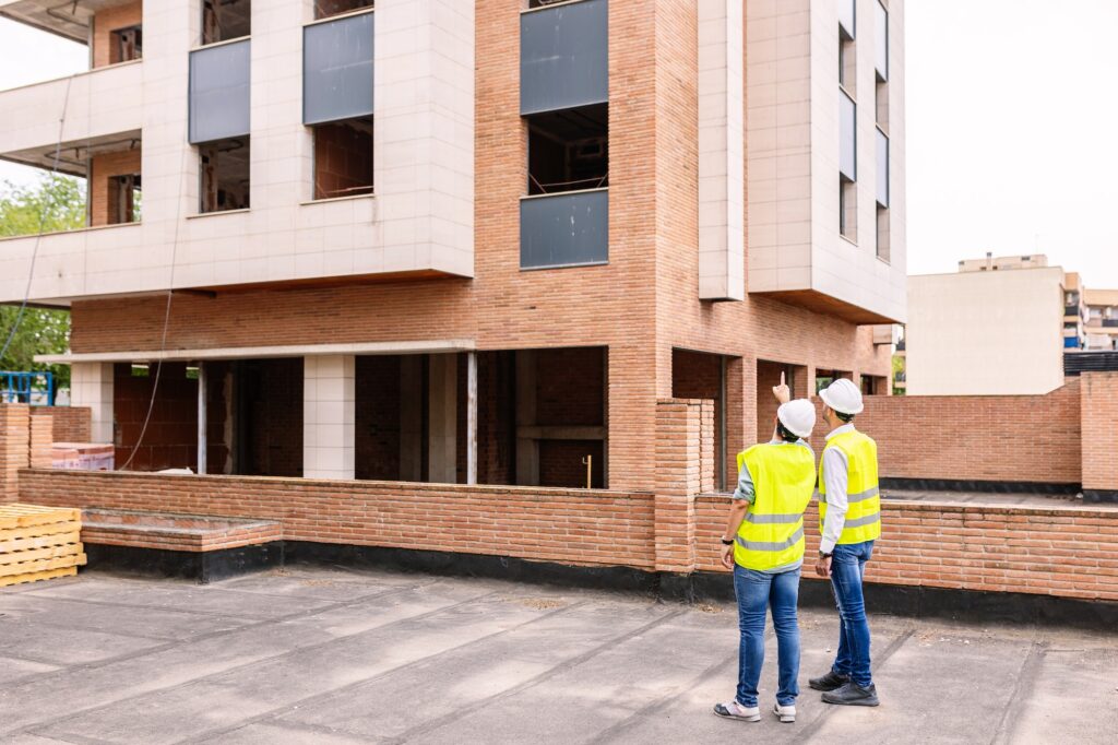 Professional engineers architect workers talking at building construction site